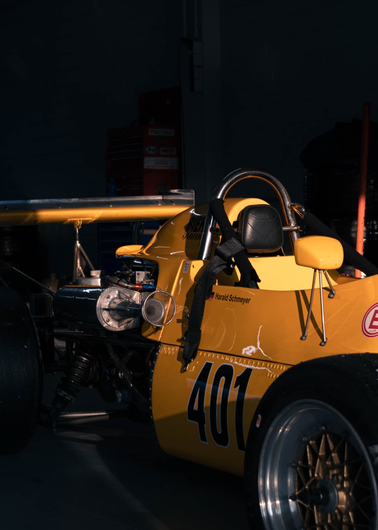 Heckansicht eines gelben historischen Formel-Wagens mit Startnummer 401 in der Werkstatt