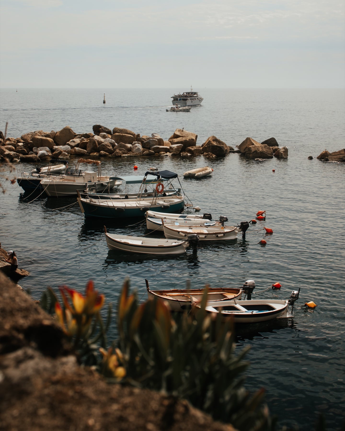 Kleine Fischerboote im Hafen der Cinque Terre, sanftes Licht über dem Wasser